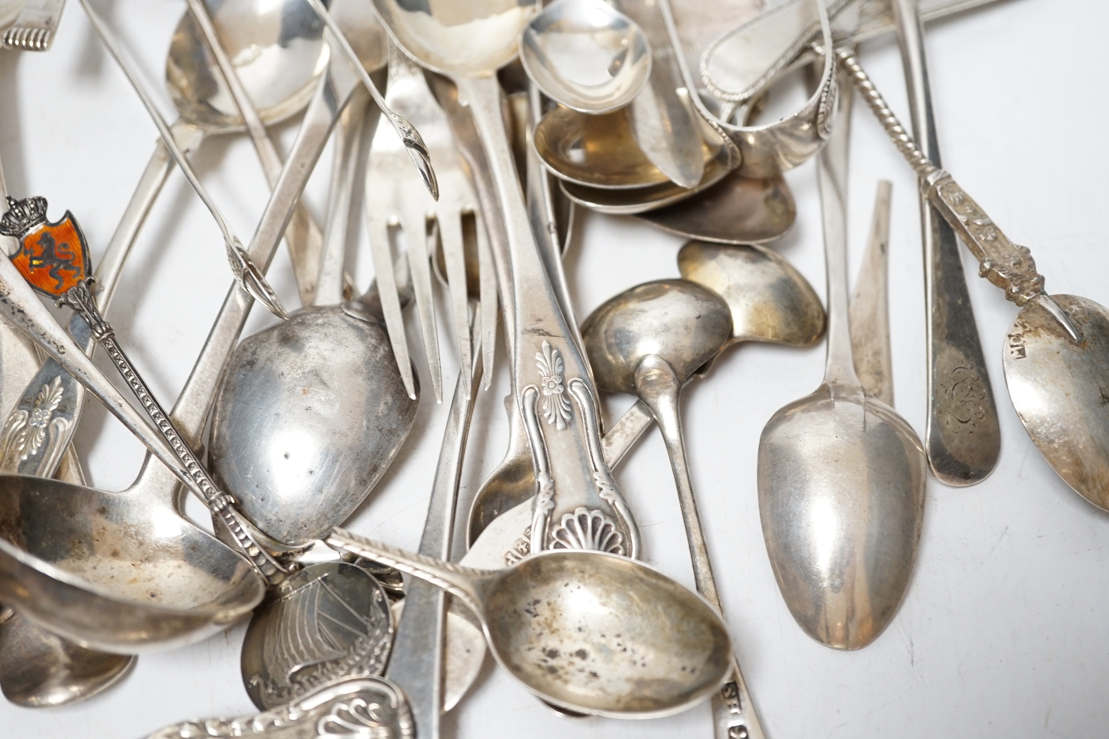 A small quantity of assorted 19th century and later silver flatware, two white metal spoons and a Victorian 'Rum' wine label, 18.2oz.